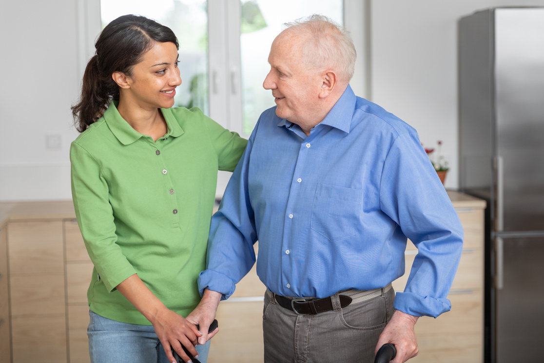 Home caregiver helping senior man